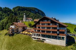 un hôtel situé sur une colline à côté d'un bâtiment dans l'établissement Hotel und Naturhaus Bellevue, à Seelisberg