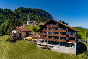 a hotel on a hill next to a building at Hotel und Naturhaus Bellevue in Seelisberg