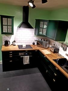 a kitchen with green walls and a wooden counter top at SWIFT HALF in Ballyconnell