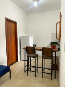 a kitchen with a table and two chairs and a refrigerator at Apartamentos Terra Mar in Trancoso