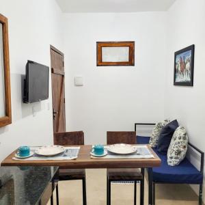 a dining room with a wooden table and chairs at Apartamentos Terra Mar in Trancoso
