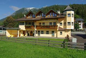 ein großes Haus mit einem Zaun davor in der Unterkunft Tonis Appartements am Achensee in Achenkirch