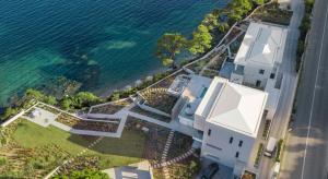 uma vista aérea de uma casa branca ao lado da água em Luxury Villas Skiathos em Skiathos Town