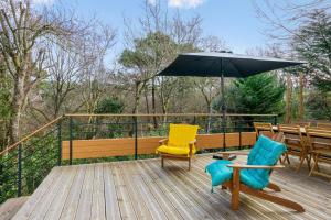 a patio with two chairs and an umbrella on a deck at Appartement Bleuet - Welkeys in Arcachon