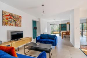 a living room with a blue couch and a tv at Appartement Bleuet - Welkeys in Arcachon