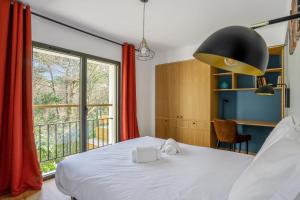 a bedroom with a bed and a large window at Appartement Bleuet - Welkeys in Arcachon
