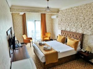 a hotel room with a bed and a table and chairs at Rose Suite & Hotel in Büyükçekmece