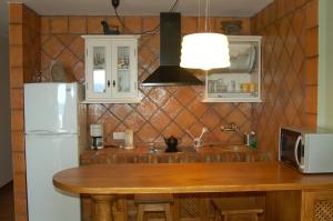 a kitchen with a wooden table and a white refrigerator at Apartamentos Las Clacas in Playa Blanca