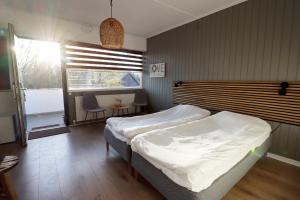 1 dormitorio con 2 camas y ventana en Strandmotellet, en Greve