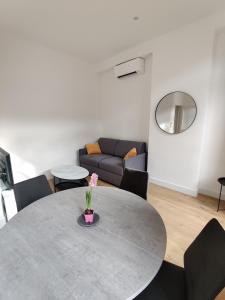 a living room with a table and a couch at T2 neuf tout équipé, climatisé in Marseille