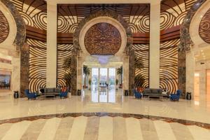 a lobby with blue chairs and a large lobby with at Triumph Luxury Hotel in Cairo