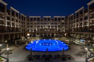 a large pool in front of a building at night at Triumph Luxury Hotel in Cairo