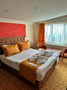 a bedroom with a large bed and a red brick wall at Rose Suite & Hotel in Büyükçekmece