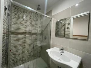 a bathroom with a shower and a sink and a mirror at Hotel 26 in Milan