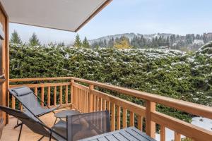 eine Veranda mit 2 Stühlen und einem Tisch auf einer Terrasse in der Unterkunft Appartement Périade - Welkeys in Megève