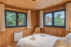 ein Schlafzimmer mit einem Bett und zwei Fenstern in der Unterkunft Appartement Périade - Welkeys in Megève