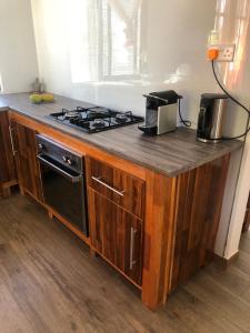 a kitchen counter with a stove and a microwave at Maison familiale à Ile Maurice in Mahébourg