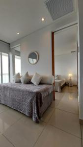 1 dormitorio con 1 cama grande y espejo en Apartamento en Lujoso Edificio H2 Plaza Bocagrande, en Cartagena de Indias