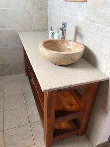 a bathroom with a stone sink on a counter at Maison familiale à Ile Maurice in Mahébourg