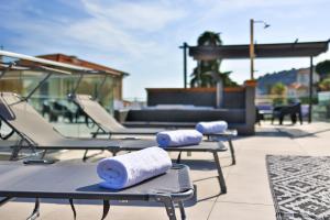 a row of lounge chairs with rolled towels on them at Le Vallaya Suites & Spa in Menton