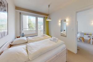 - une chambre avec 2 lits et une fenêtre dans l'établissement Au Reduit 401, à Saint-Moritz