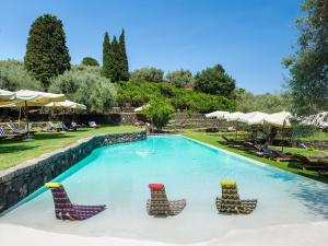 a swimming pool with lounge chairs and umbrellas at Monaci delle Terre Nere in Zafferana Etnea