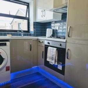 a kitchen with a blue tape on the floor at Beautiful Modern Apartment on Wick Lane in London