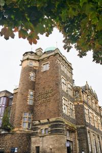 een groot bakstenen gebouw met een bord erop bij Stirling Highland Hotel- Part of the Cairn Collection in Stirling