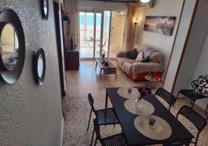 a living room with a table and chairs and a couch at Sea view 3-bedroom flat in Puerto de Mazarron in Puerto de Mazarrón
