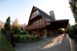 una gran casa de madera con techo de gambrel en Dom w Szczyrku - stylowy drewniany dom z kominkiem, en Szczyrk