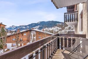 a balcony with chairs and a view of mountains at Superb ski-in apartment in Megève - Welkeys in Megève