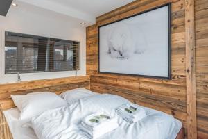 Schlafzimmer mit einem TV und einem Bett mit weißer Bettwäsche in der Unterkunft Superb ski-in apartment in Megève - Welkeys in Megève