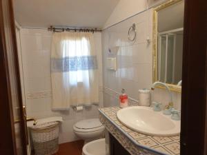 a bathroom with a sink and a toilet at Villa Alice e Silvia - Chia in Chia