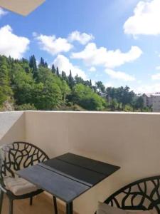a table and chairs on a balcony with a view at Apartments at Ljubovic Hill Park in Podgorica