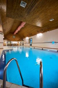 a large blue swimming pool with a wooden ceiling at Stirling Highland Hotel- Part of the Cairn Collection in Stirling