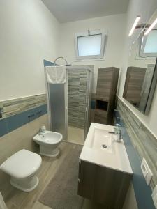 Baño blanco con aseo y lavamanos en La casetta degli ulivi, en Petrosino