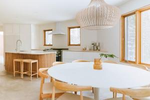 a kitchen and dining room with a white table and chairs at Okt Häus in Nordegg