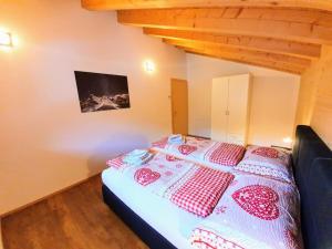 um quarto com uma cama com cobertores vermelhos e brancos em Chalet Eigernordwand em Grindelwald