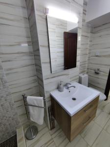 La salle de bains est pourvue d'un lavabo et d'un miroir. dans l'établissement Ania's Apartment, à Horezu