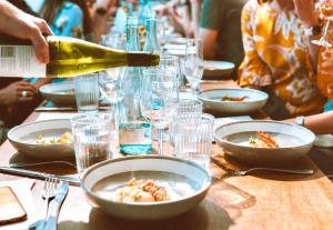 eine Person, die Wein in eine Schüssel mit Essen auf einem Tisch gießt in der Unterkunft Pura Villa- Buganvillas Ayamonte in Ayamonte