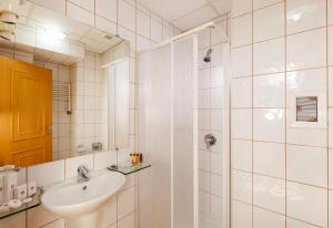 a white bathroom with a sink and a shower at Arte Sofia Hotel in Sofia