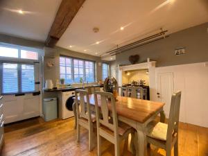 a kitchen and dining room with a wooden table and chairs at Beautiful 17th century coach house off high street in Marlborough