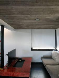 sala de estar con sofá y TV de pantalla plana en Casa en Villa Carlos Paz en Villa Carlos Paz