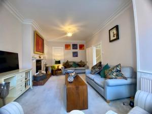 a living room with a couch and a tv at Beautiful 17th century coach house off high street in Marlborough