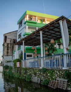 un edificio con porche, sombrilla y agua en Hotel Sabana en Flores