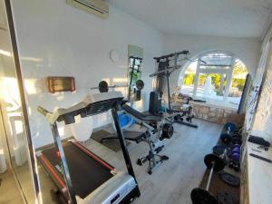a room with a gym with a treadmill and weights at La Villa Romantica Résidence de vacances Les Tres Cales Espagne in Les tres Cales
