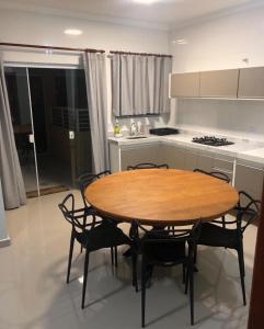- une cuisine avec une table et des chaises en bois dans la chambre dans l'établissement Apartamento aconchegante em frente à praia., à Ubatuba