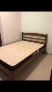 Cette chambre comprend un lit en bois. dans l'établissement Apartamento aconchegante em frente à praia., à Ubatuba