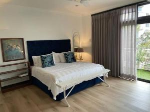 una camera da letto con un letto grande e una grande finestra di Stylish & New 4 Bedroom Point Waterfront Penthouse a Durban