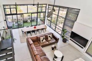 un soggiorno con un divano e un tavolo di Stylish & New 4 Bedroom Point Waterfront Penthouse a Durban